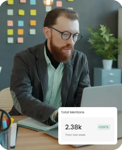 Seorang ahli strategi digital sedang menganalisis data Total Mentions sebesar 2.38k yang naik 21,67% pada dashboard website custom untuk memantau popularitas brand klien.
